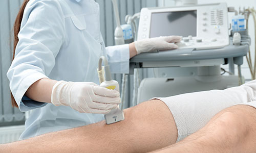 A doctor conducting ultrasound examination of a knee